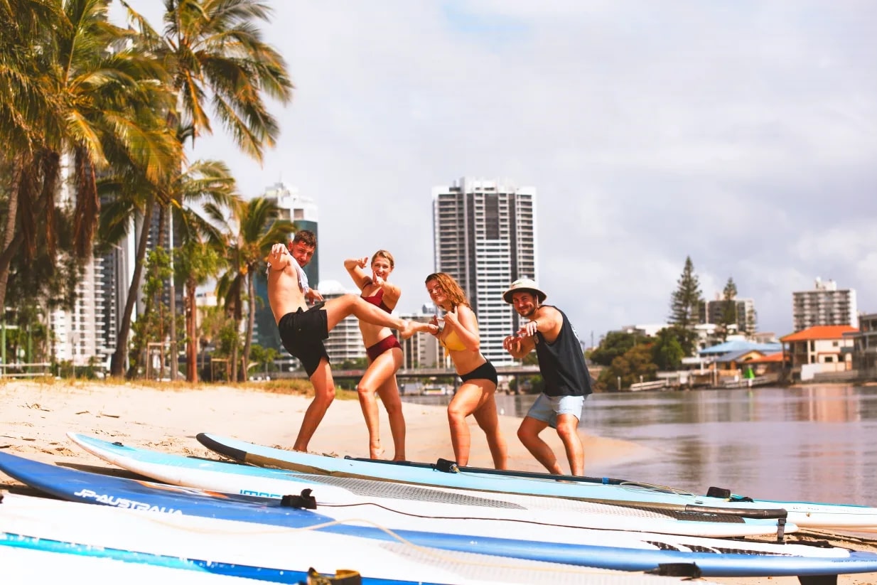 Budds hostel guests learning to stand up paddle board at Budds Beach Gold Coast