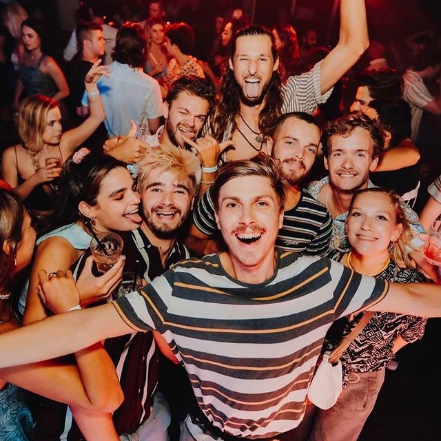 Group of Budds backpackers in a local nightclub posing for a closeup photo