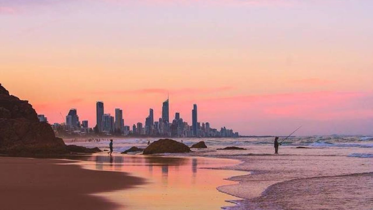 Gold Coast beach at sunset with fisherman in foreground