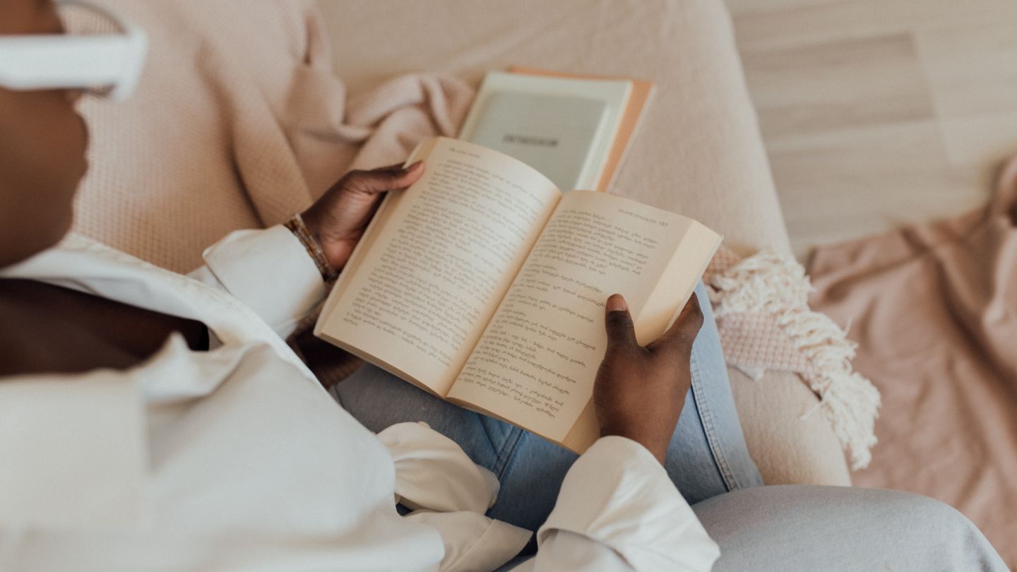 Backpacker chilling reading a book in the dorm bed