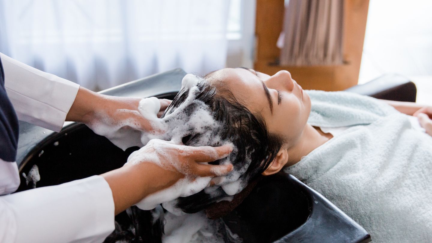 Woman receiving hair shampoo wash