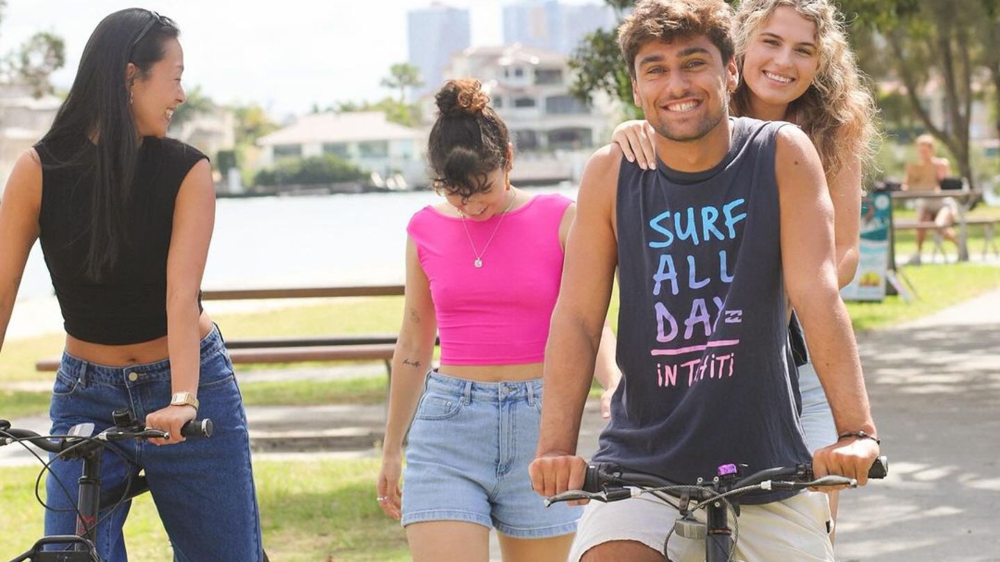 Three backpackers with two riding bikes along the waterfront of Budds Beach