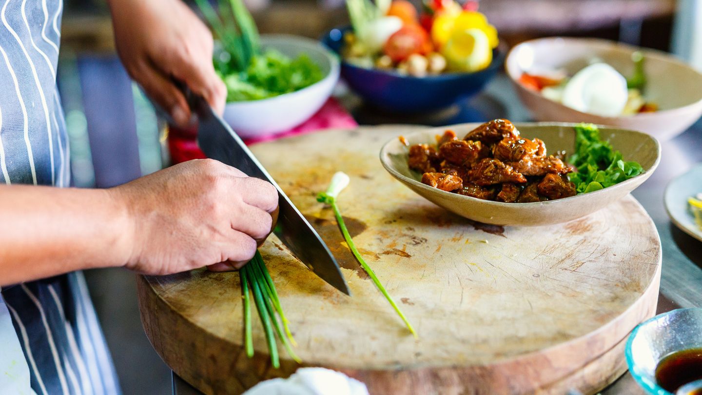 Closeup of hostel guest preparing food on a wooden platter