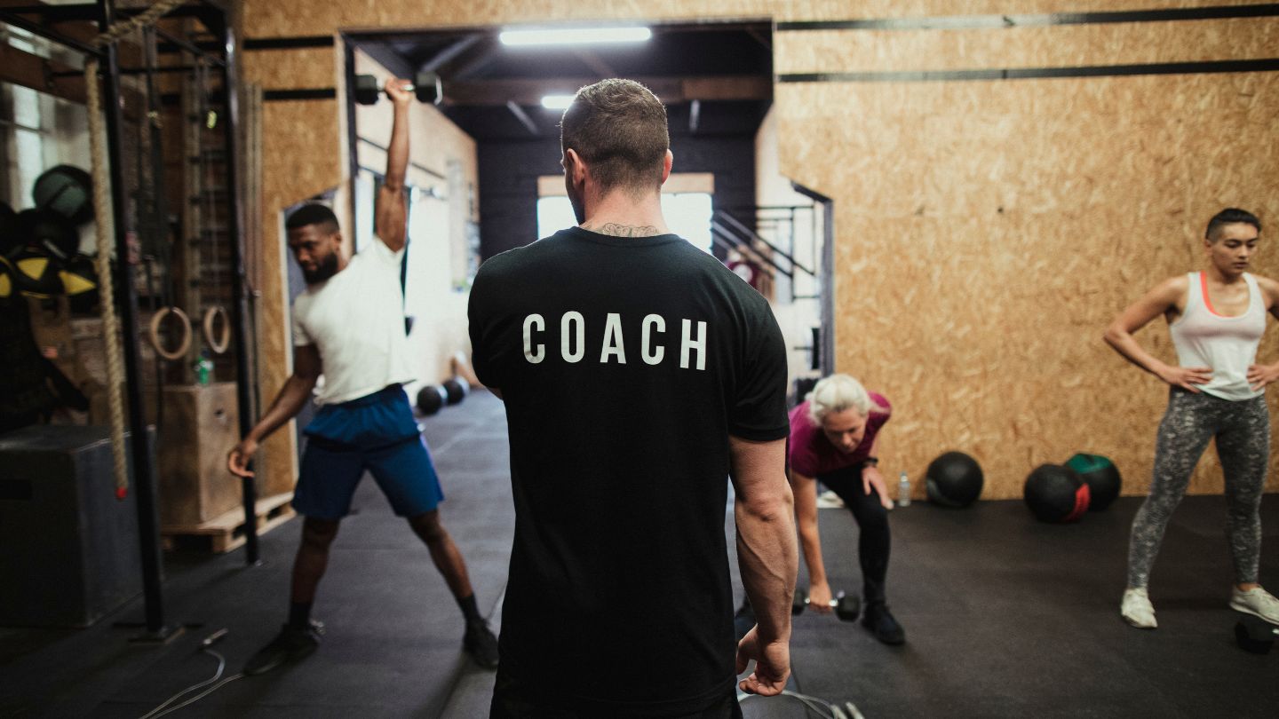 Fitness coach instructing students in his fitness class