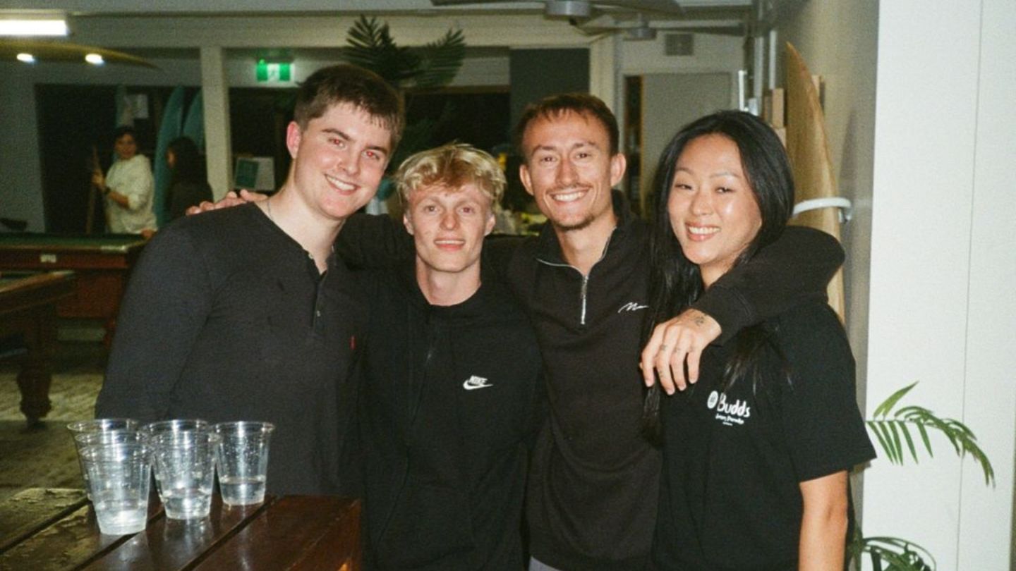 Budds in Surfers staff and hostel guests smiling for small group photo